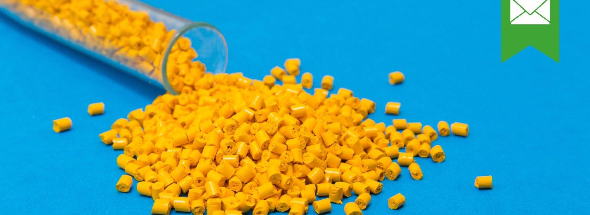 Gelbe Plastikpalletts rollen aus einem Reagenzglas auf blauem Untergrund