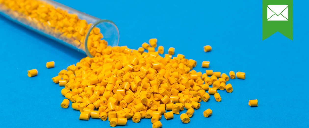 Gelbe Plastikpalletts rollen aus einem Reagenzglas auf blauem Untergrund