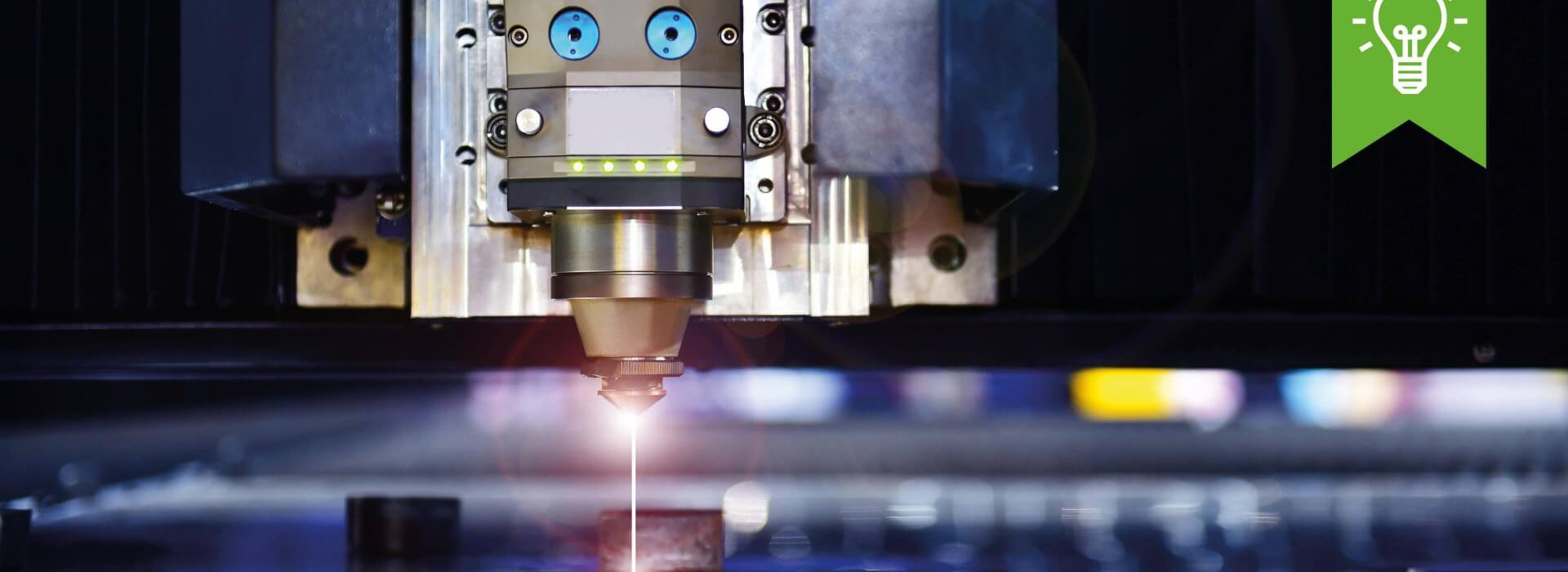 Upkino Eine Maschine schneidet Metall mit einem rotem Laser.