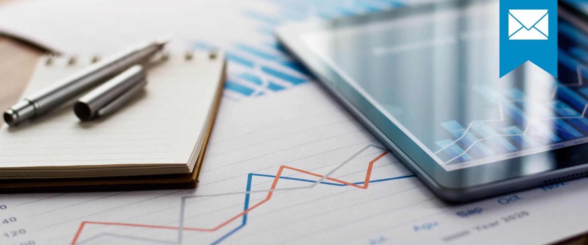 Notizblock, Tablett mit Balkendiagramm und ein Ausdruck mit Liniendiagramm sollen die Entwicklung verschiedener Kennzahlen darstellen
