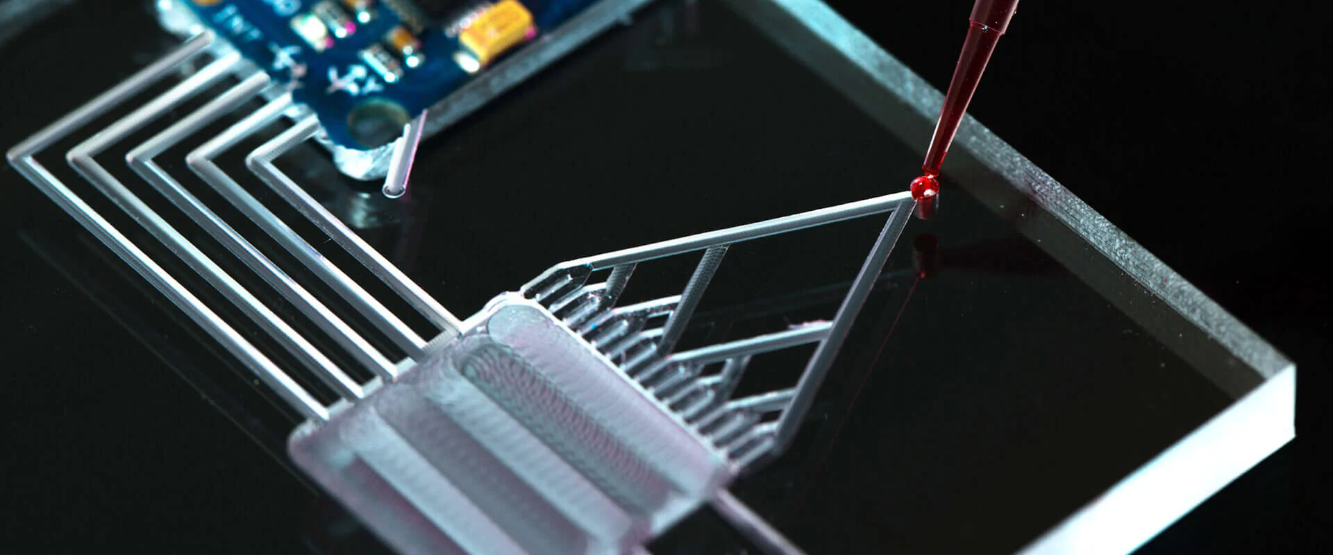 Microfluidics Bildbeschreibung / description: Glasplatte mit Gravuren in Form eines Baumdiagramms, eine rote Flüssigkeit wird auf den Startpunkt des Diagramms gegeben